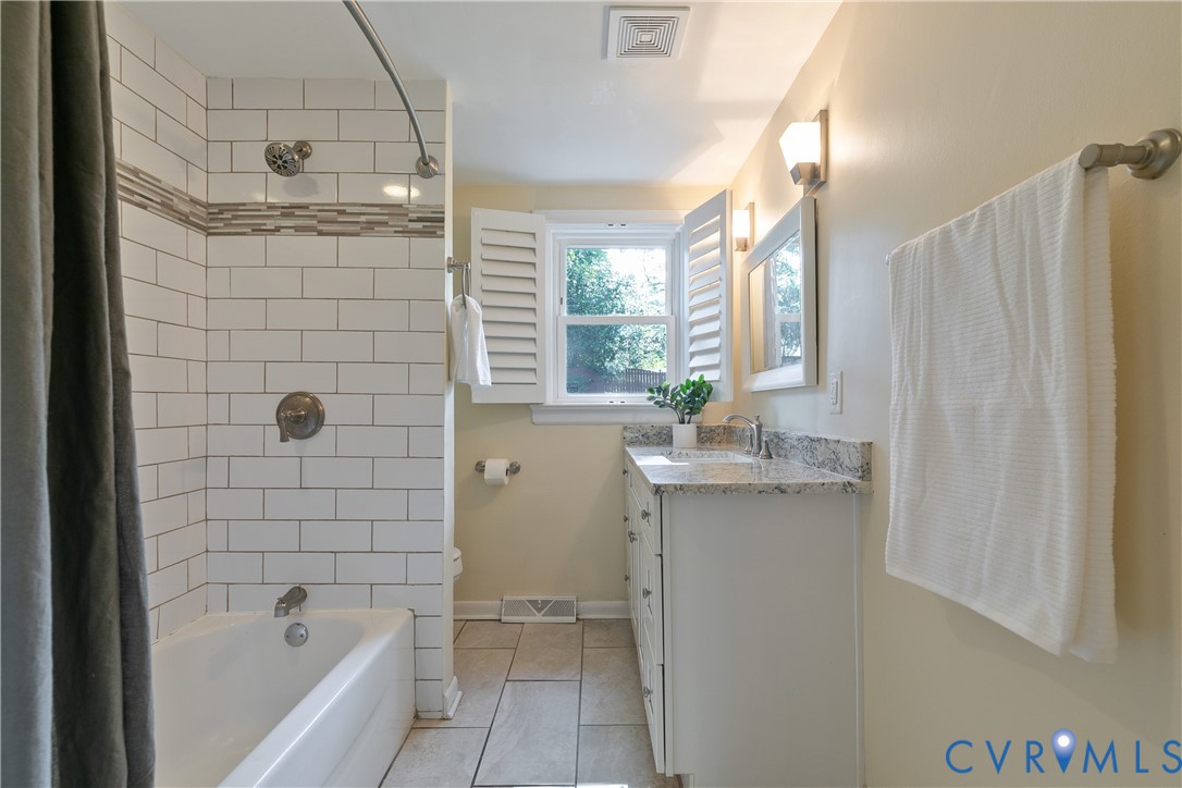 Bathtub with subway tile surround, mosaic accent tile, and a shower head