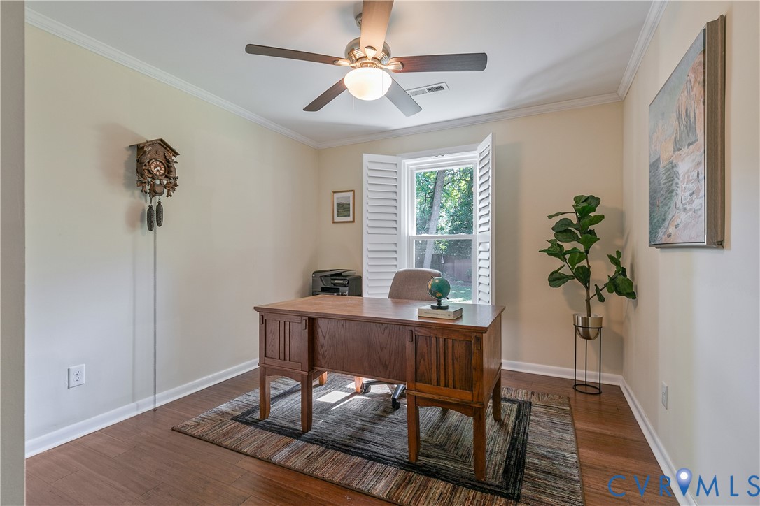 Hardwood-finish flooring, crown molding, ceiling fan with integrated lighting, and window with plantation shutters