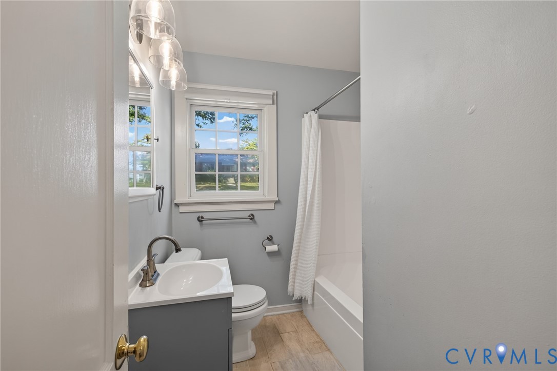 Modern vanity with integrated sink, brushed nickel faucet, and overhead three-bulb vanity light