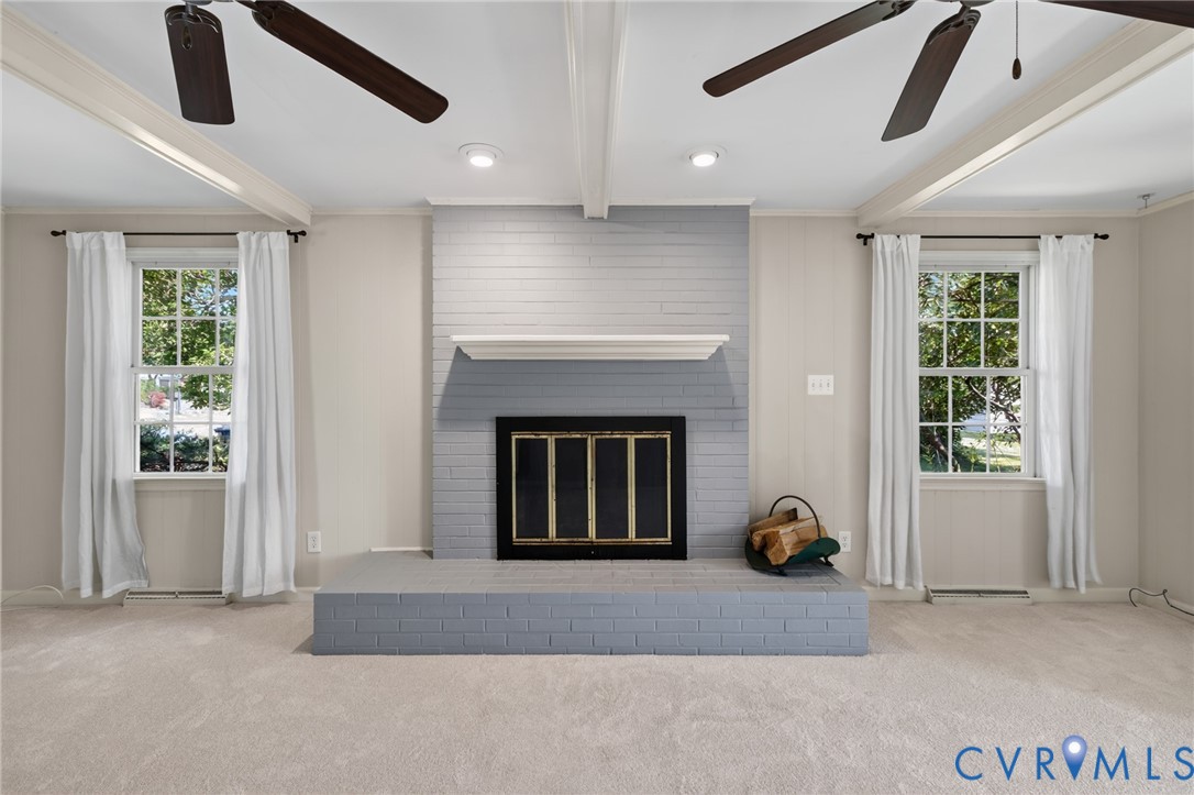 Recessed lighting illuminates a painted brick fireplace with a mantel