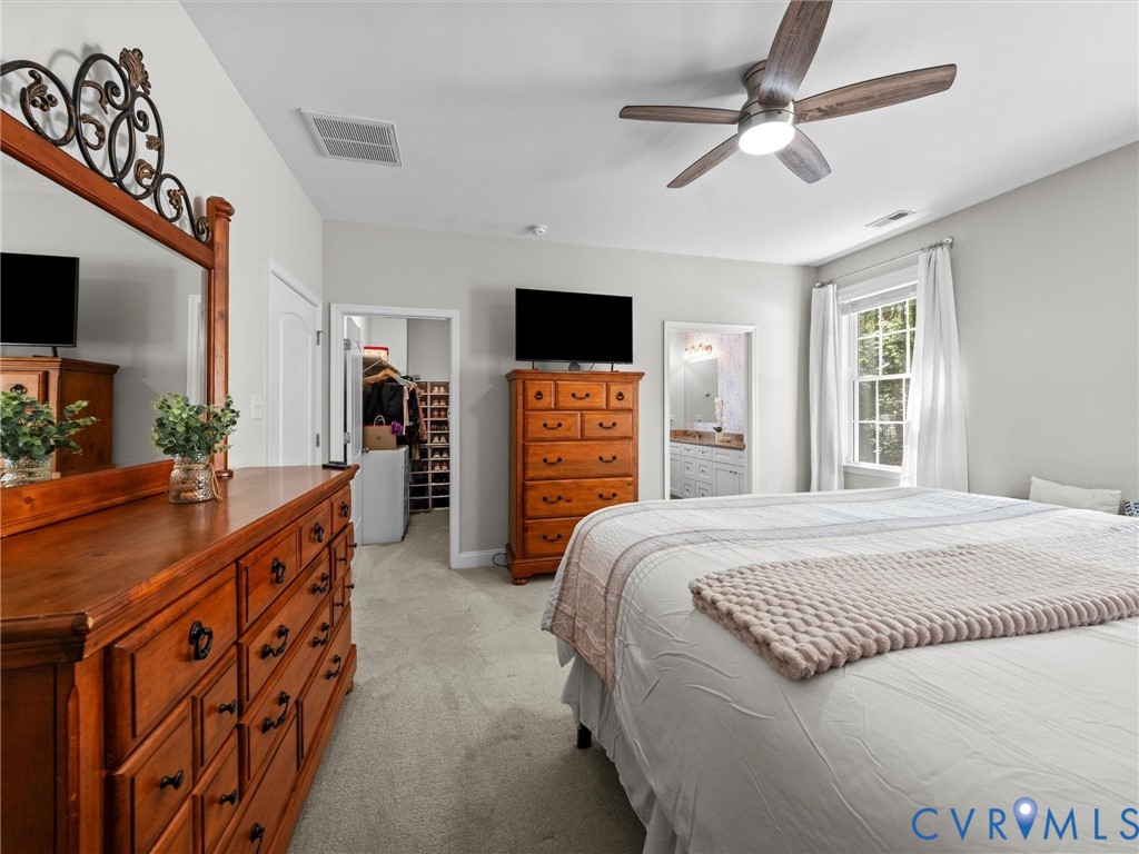 Carpeted flooring, ceiling fan with integrated lighting, window with white curtains, and a doorway to an adjacent room