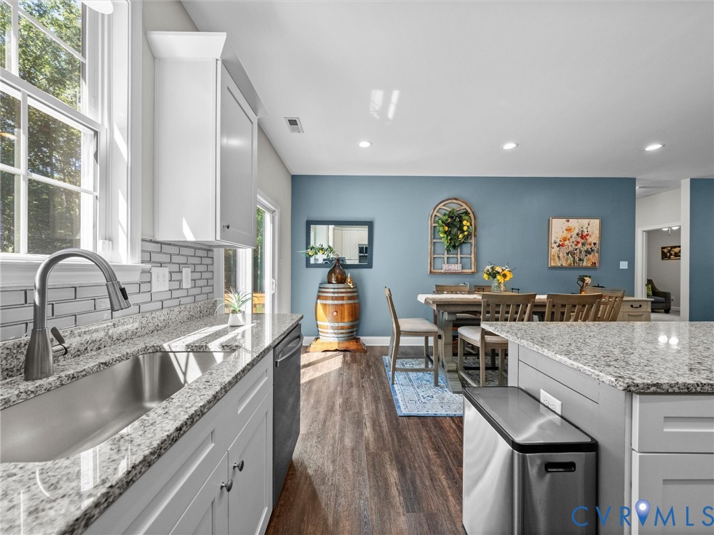 White cabinetry with granite countertops and a stainless steel sink