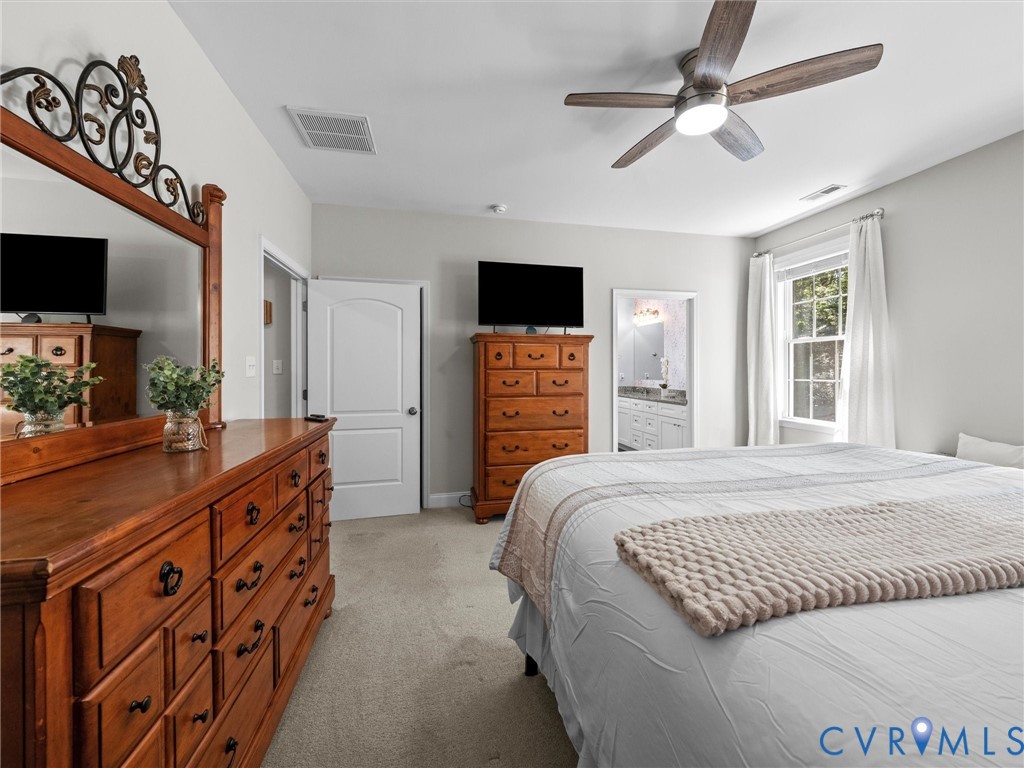 Recessed lighting, wood-finish ceiling fan, neutral wall tones, carpeted flooring, and a large window with natural light