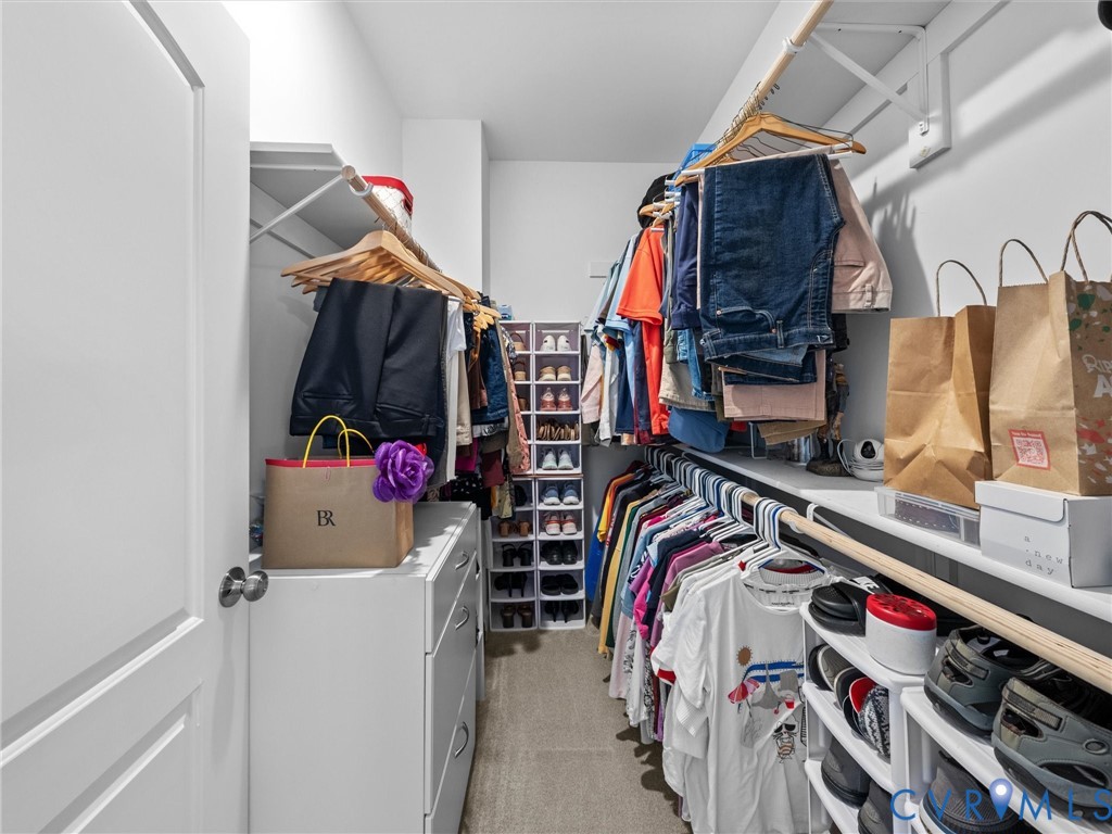 Walk-in closet featuring built-in shelving, hanging rods, and integrated drawer storage