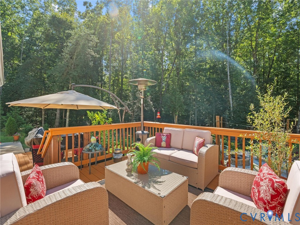 Expansive wood deck with a full-height wood railing, surrounded by mature trees