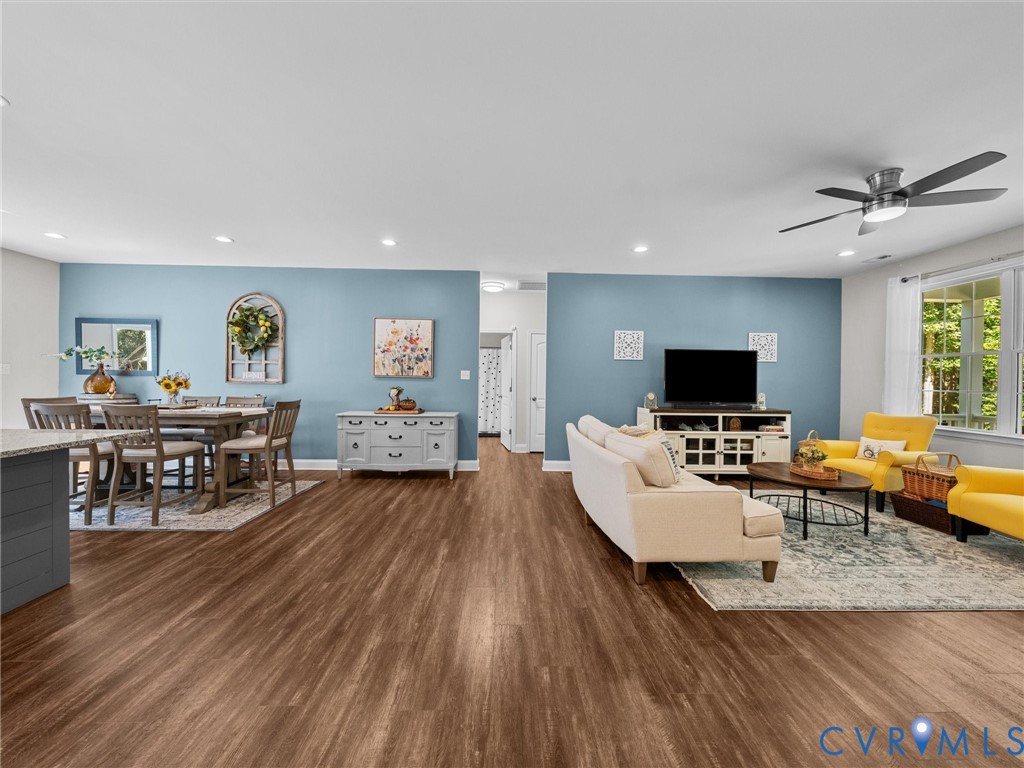 Wood-finish flooring throughout, recessed ceiling lighting, a modern ceiling fan, and large windows with exterior views