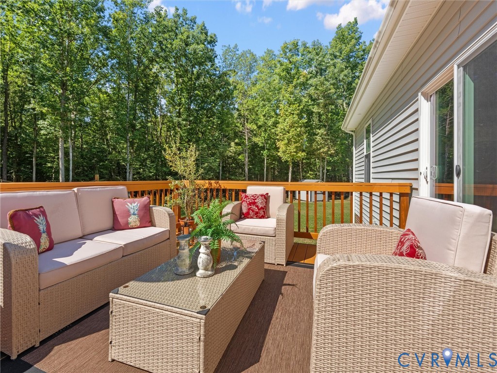 Spacious outdoor deck with a wood-tone composite surface, wood railing, and direct access to the interior via a sliding glass door