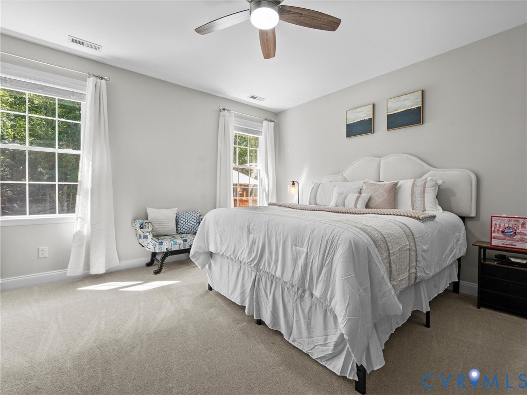 Recessed lighting, ceiling fan with wood-finish blades, two large windows, and wall-to-wall carpeting