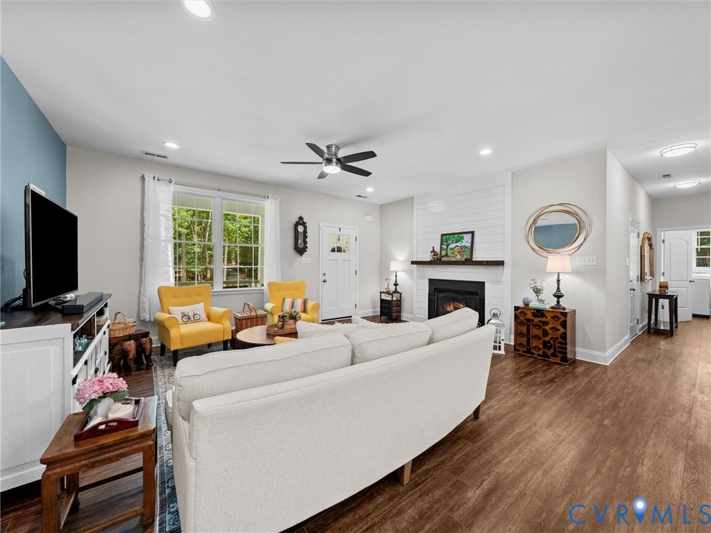 Spacious living area featuring wood-finish flooring, recessed lighting, and a ceiling fan
