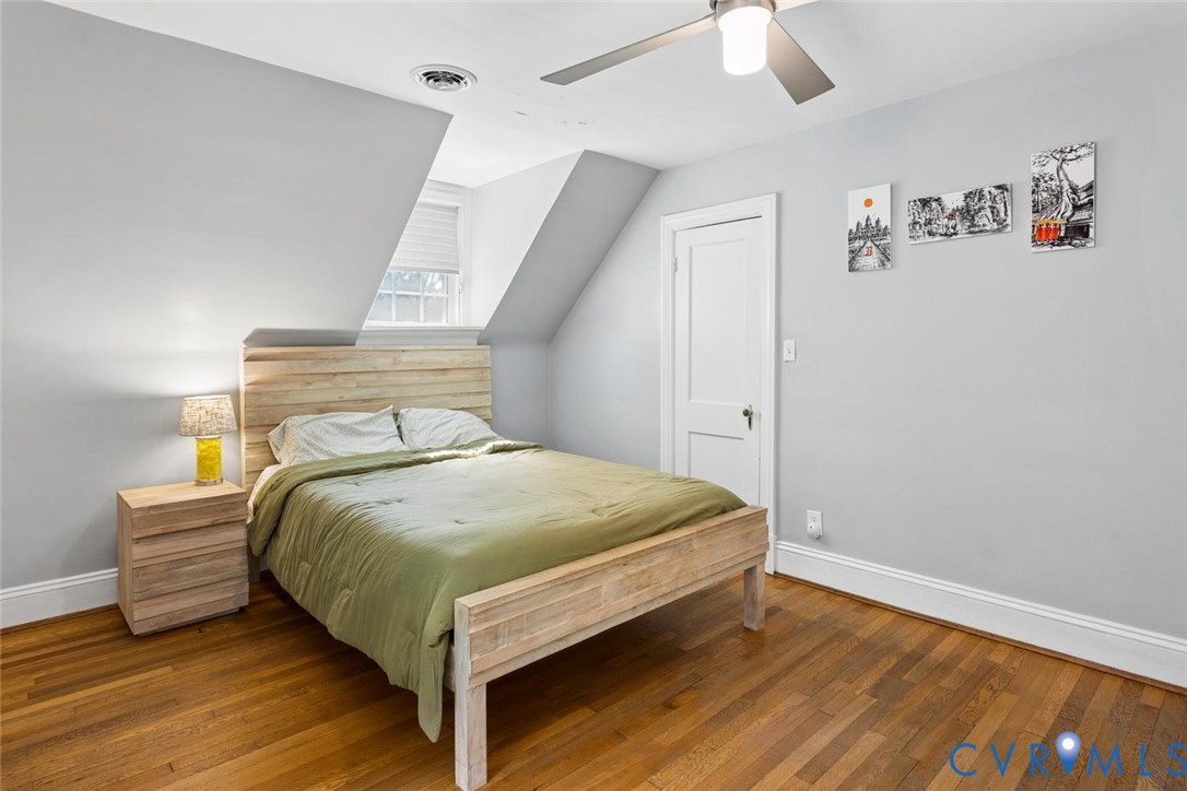 Hardwood flooring, painted walls, ceiling fan, white trim, and a window with blinds
