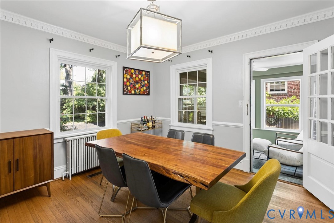 Hardwood flooring, crown molding, white trim, square semi-flush mount light fixture, and French doors
