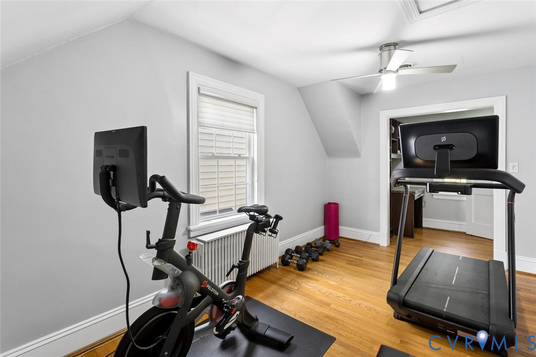 Hardwood flooring, painted walls, window with blinds, ceiling fan, and sloped ceiling