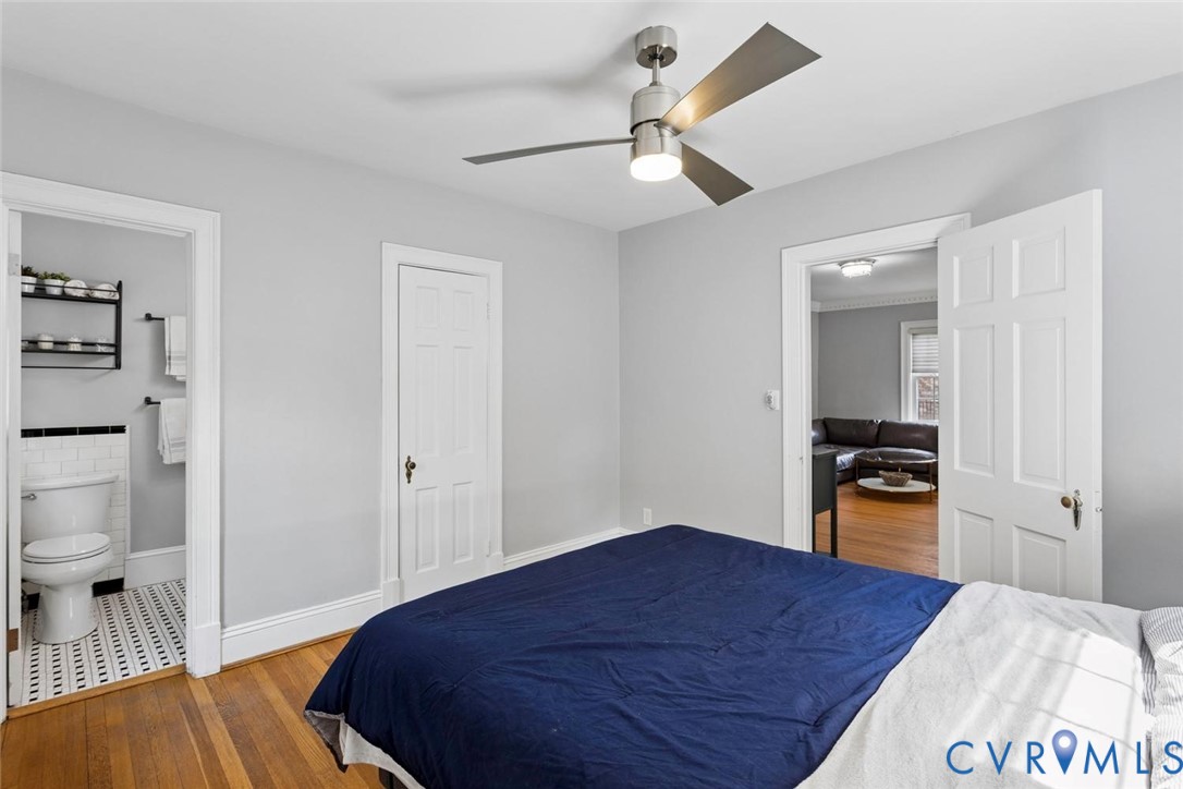 Wood-finish flooring, modern ceiling fan with lighting, white interior doors, and light-toned walls
