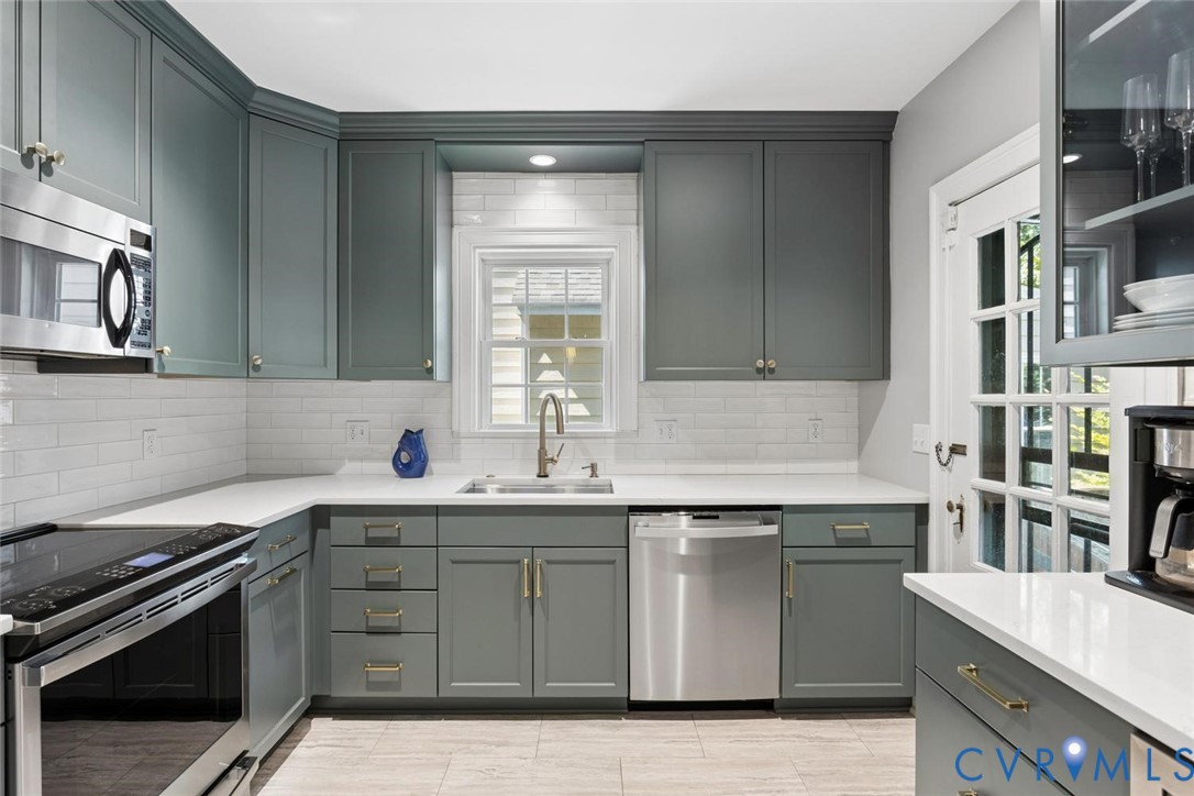 Kitchen featuring shaker-style cabinetry, white countertops, subway tile backsplash, and stainless steel appliances