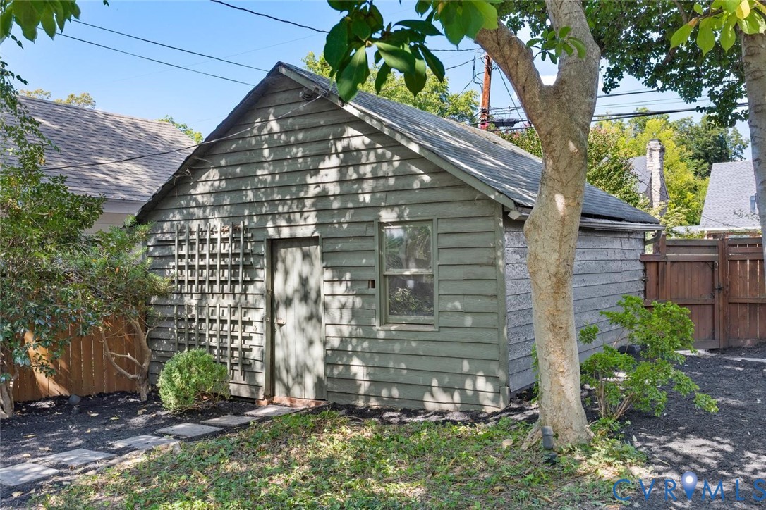 Detached outbuilding with wood siding, single window, and a trellis feature