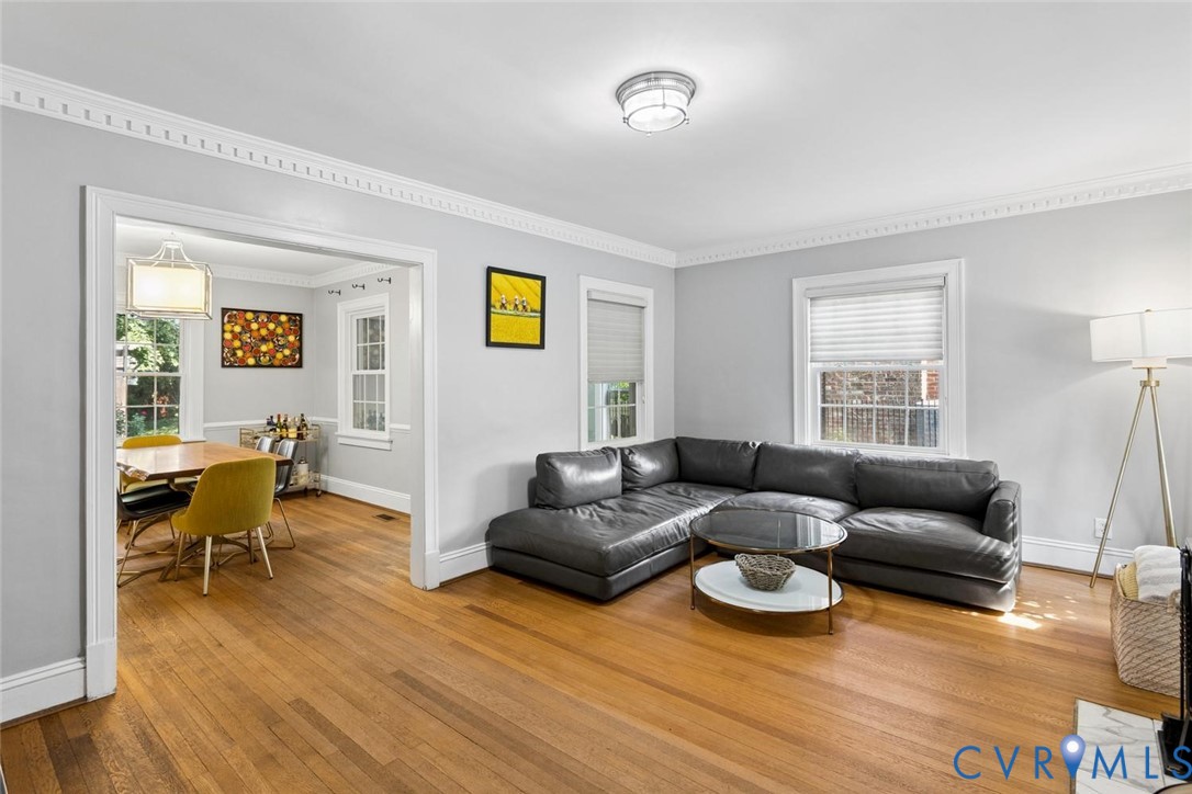 Hardwood flooring, decorative crown molding, recessed lighting, and ample natural light through multiple windows