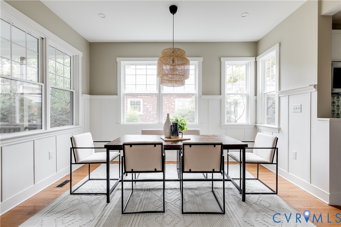 Hardwood flooring, extensive wainscoting, recessed lighting, multiple windows, and a built-in light fixture