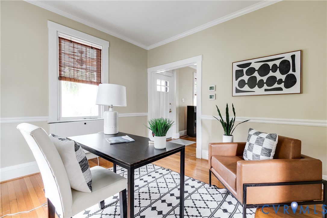 Sophisticated home office featuring hardwood flooring, crown molding, and chair rail