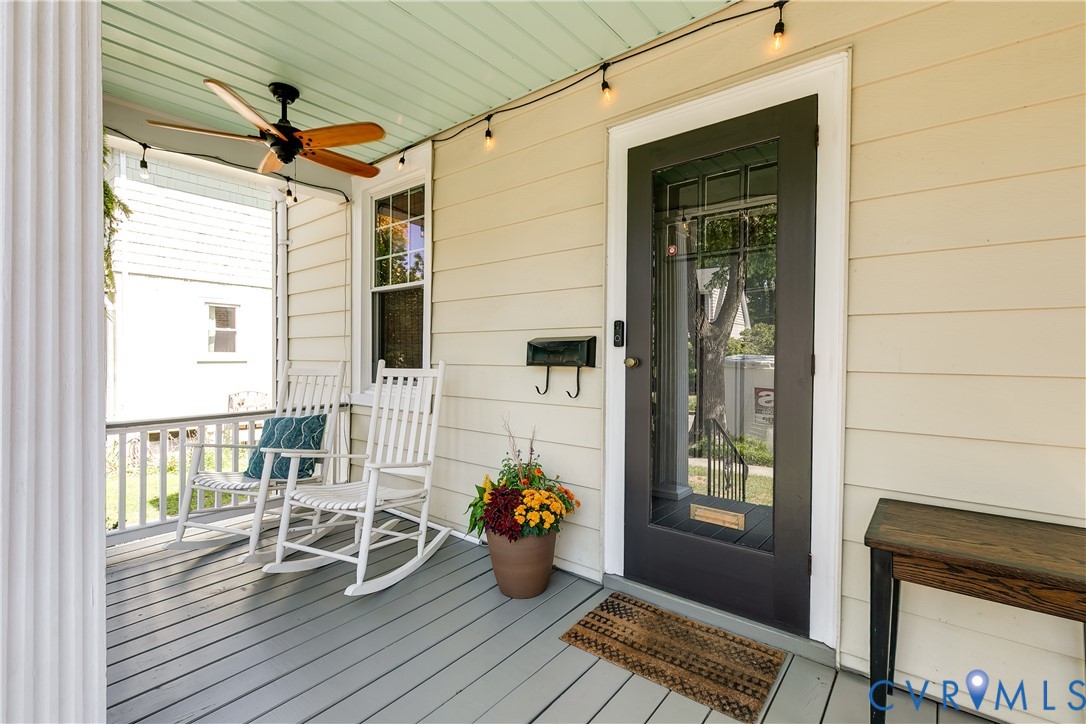 Covered front porch featuring a dark wood-finish ceiling fan, recessed lighting, white columns, and painted wood flooring