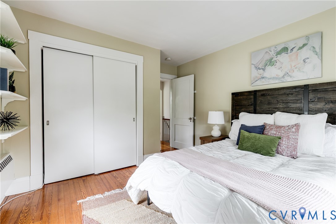 Hardwood flooring, painted walls, white trim, sliding closet doors, and built-in shelving