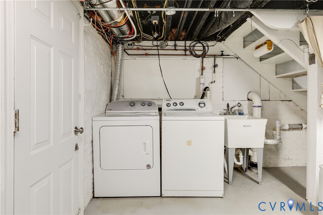 Laundry area featuring a utility sink and exposed piping