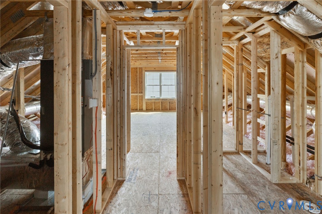 New construction framing with exposed wooden beams, subflooring, and a single window