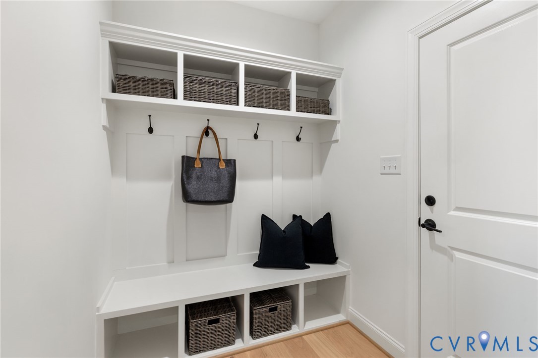 Built-in storage bench with cubbies, upper shelving, and coat hooks