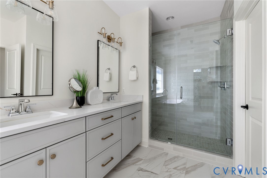 Dual vanity with light gray cabinetry and gold-tone hardware