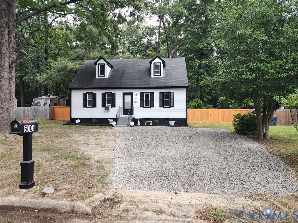 White exterior with black trim, black shutters, and two dormer windows White exterior with black trim, black shutters, and two dormer windows