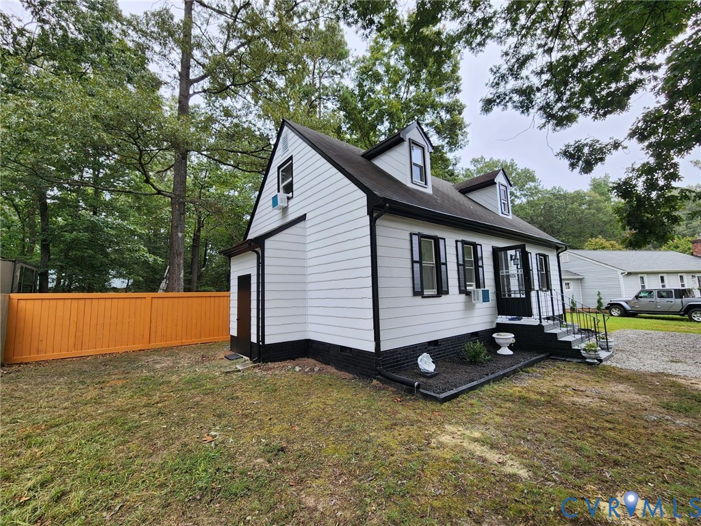 White siding exterior with black trim, black shutters, and two dormer windows White siding exterior with black trim, black shutters, and two dormer windows