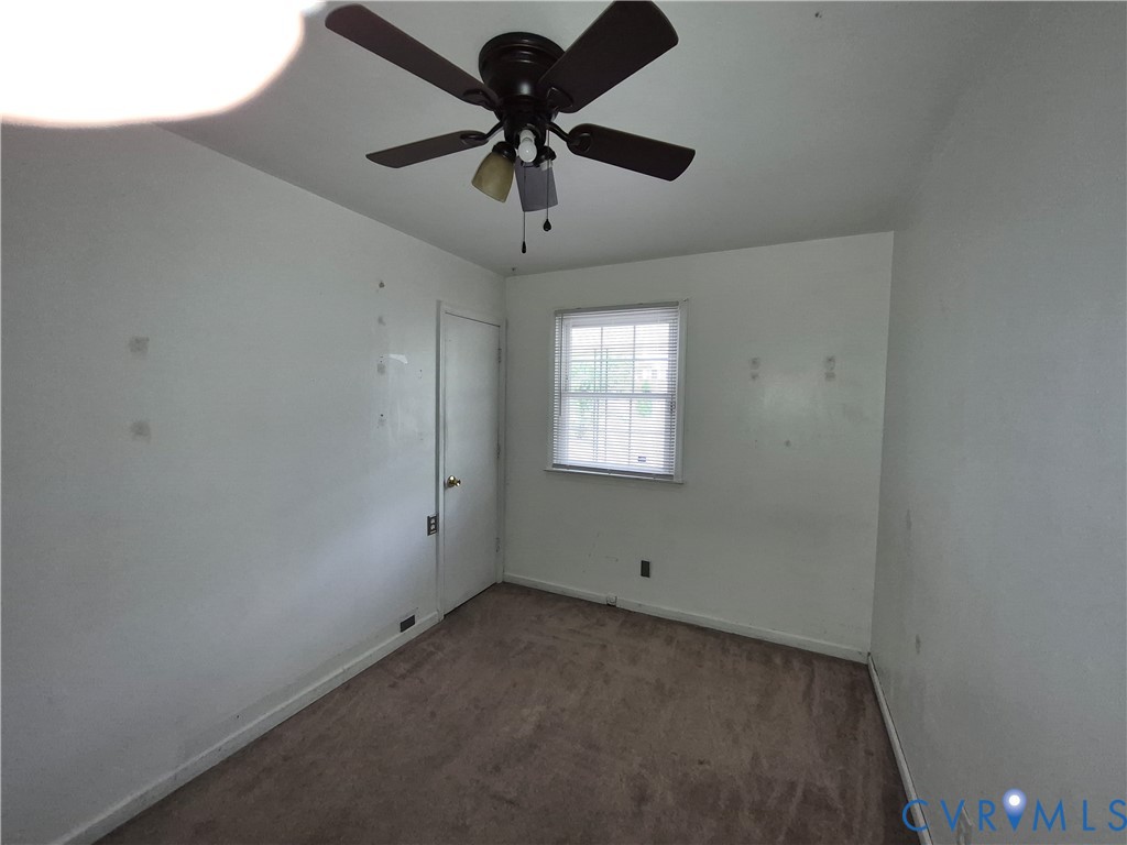 Ceiling fan with integrated lighting, carpeted flooring, and a single window