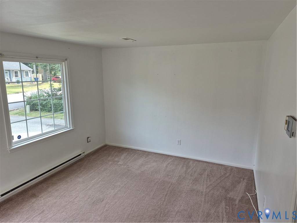 Carpeted flooring, white walls, and a window with grid panes