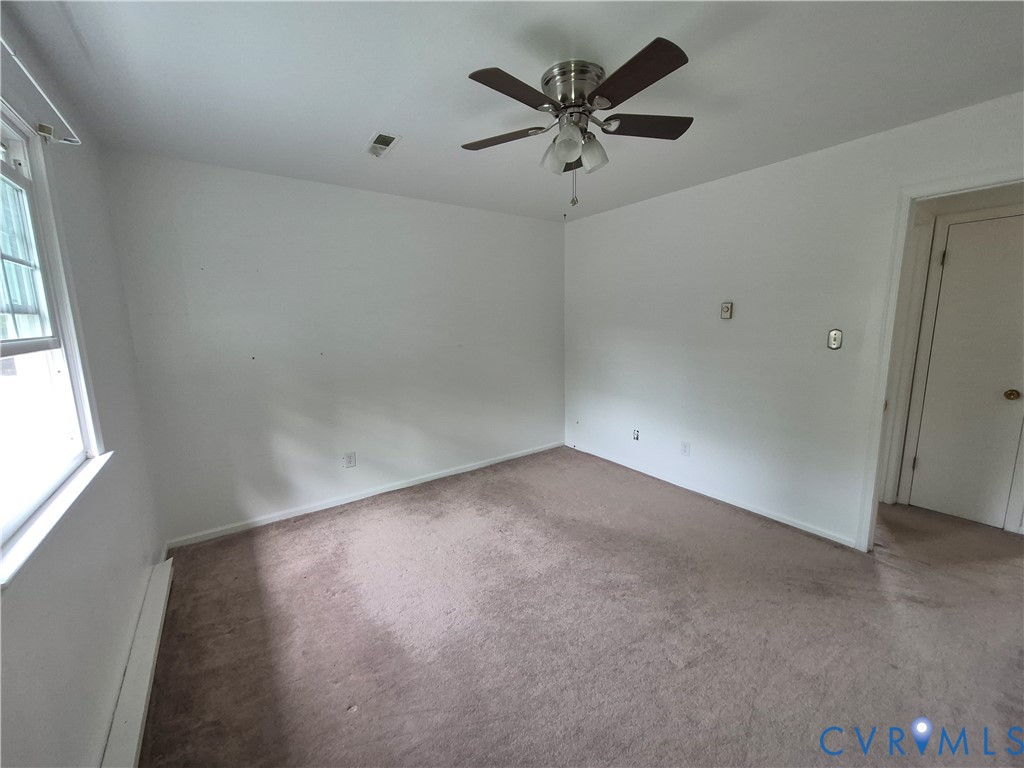 White-painted room featuring a ceiling fan with light kit, a window, and carpet flooring