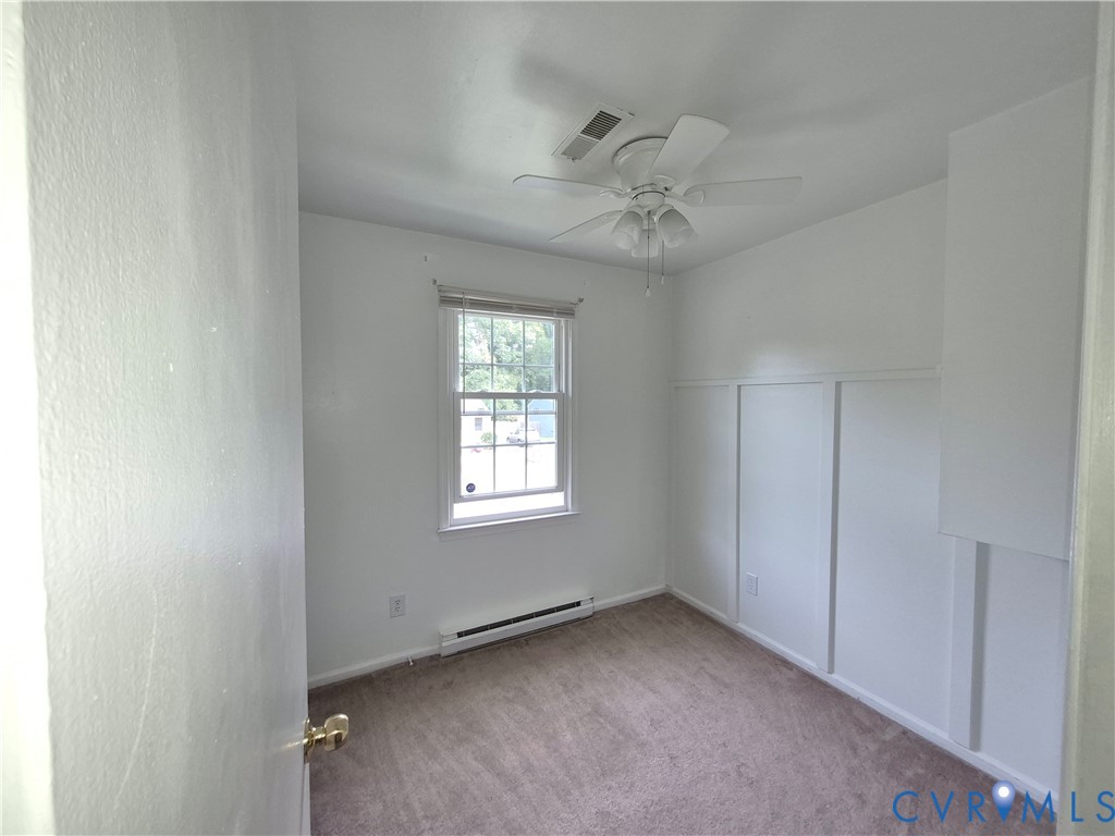 Neutral wall finishes, window with blinds, ceiling fan, carpeted flooring, and sliding closet doors