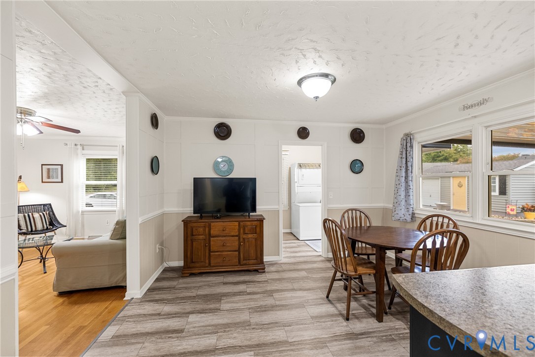 Open-concept living space with wood-finish flooring, white walls, and a built-in light fixture