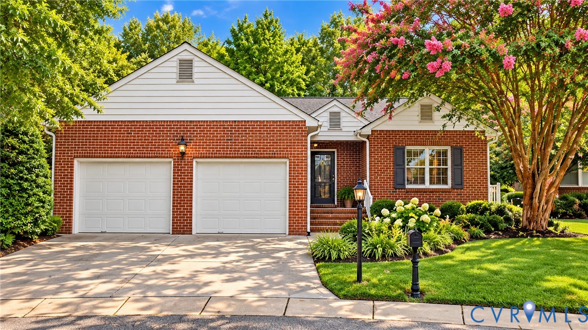 Brick exterior facade with white siding accents and a two-car garage Brick exterior facade with white siding accents and a two-car garage