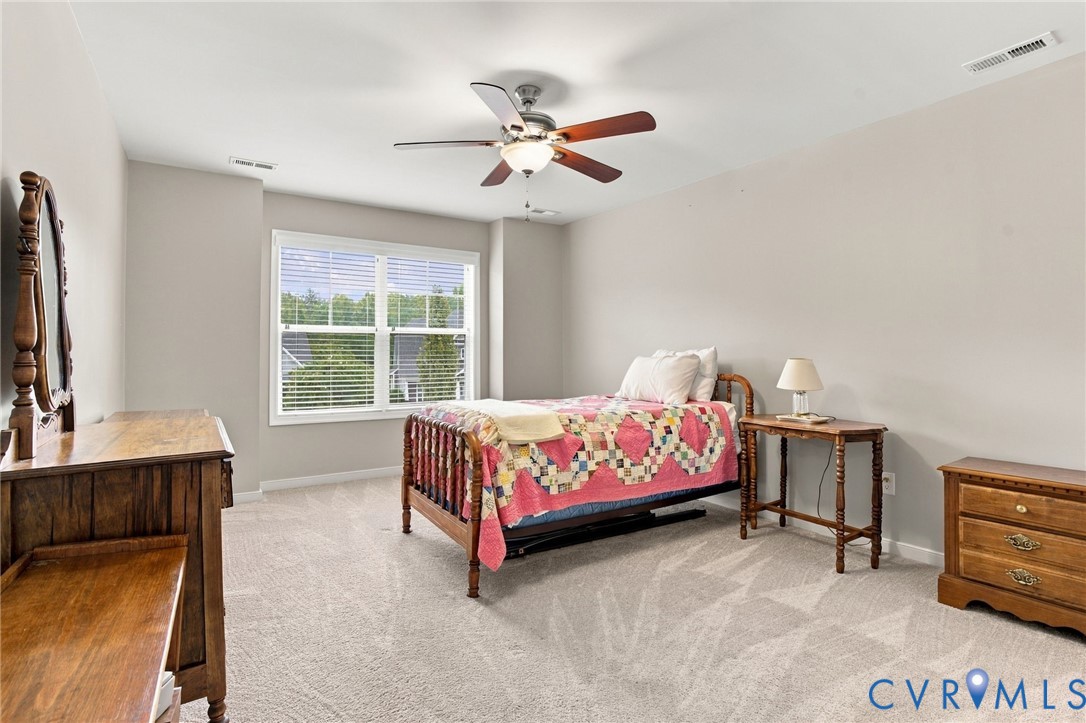 Neutral-toned walls, ceiling fan with integrated lighting, large window with blinds, and light-colored carpeting