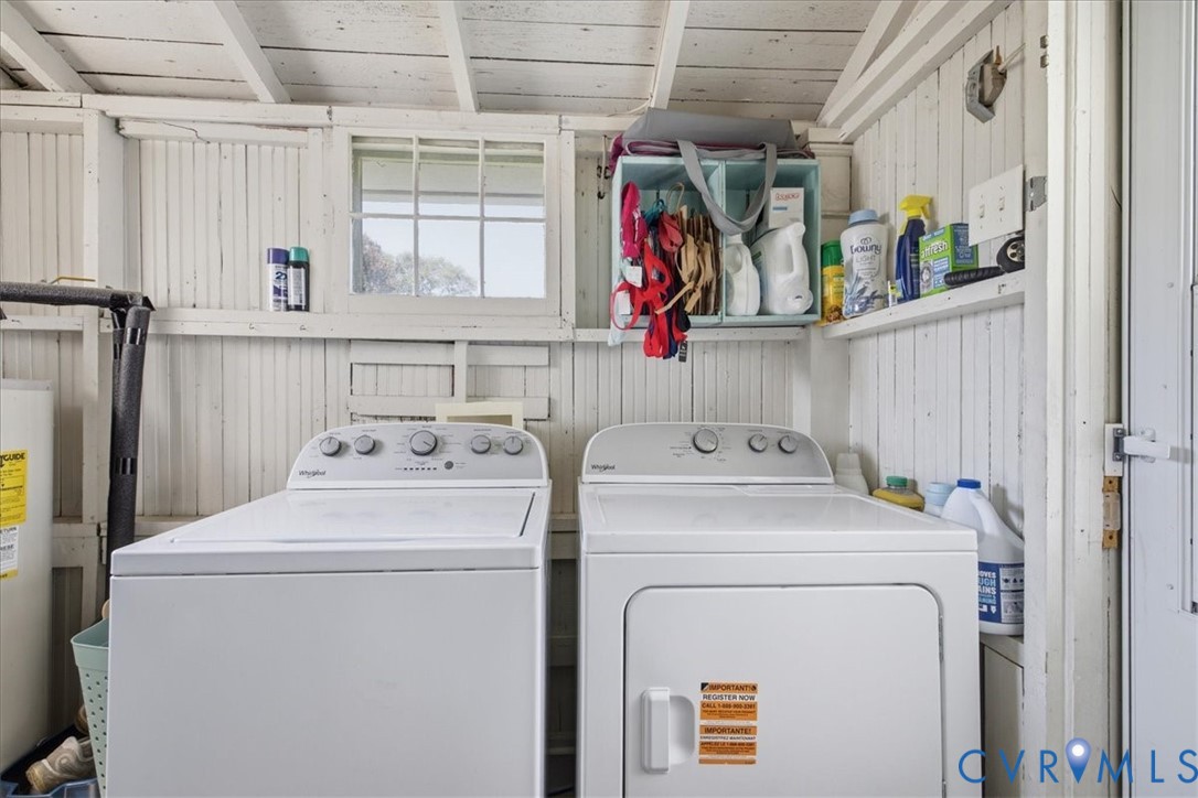 Laundry area with paneling, exposed beam ceiling, and a window