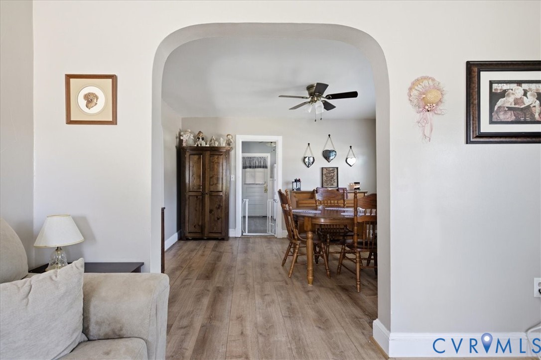 Archway opening into a dining area w ceiling fan