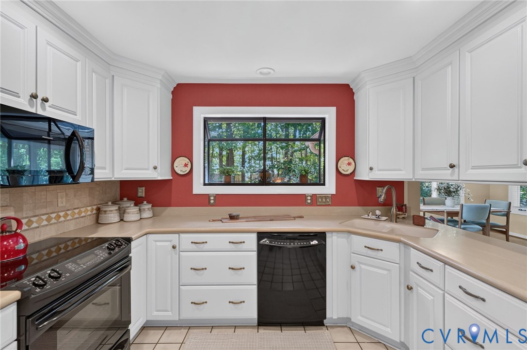 Bright, kitchen with abundant cabinetry and generous counter space featuring a nice garden window to bring in more of the natural surroundings.