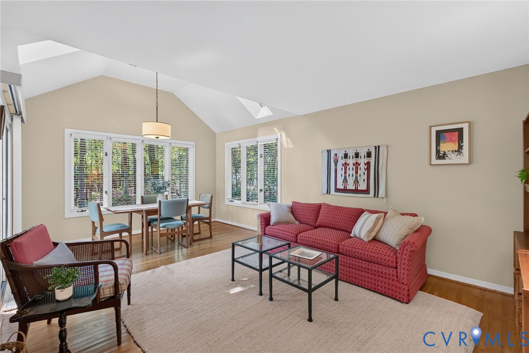 Bright family room with hardwood floors, vaulted ceiling, and abundant natural light.