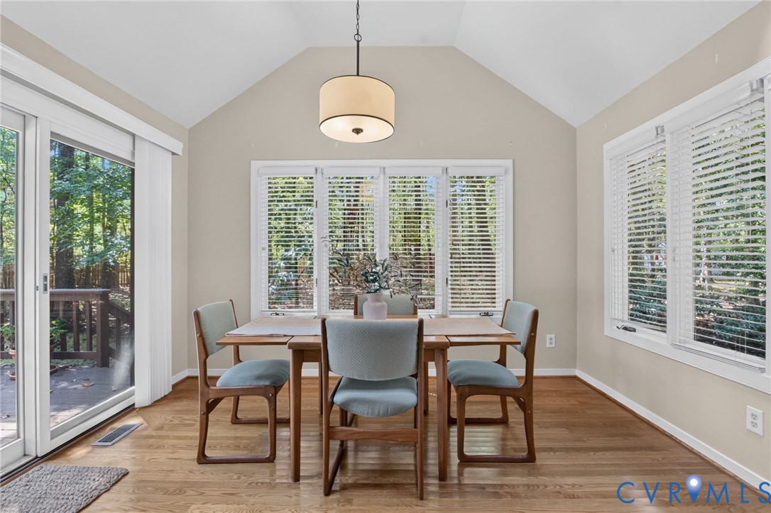 Casual dining area surrounded by windows and wooded views.