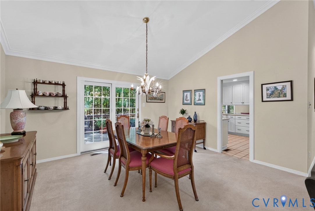 Formal dining room with sliding French doors opening to the deck with wooded views beyond.