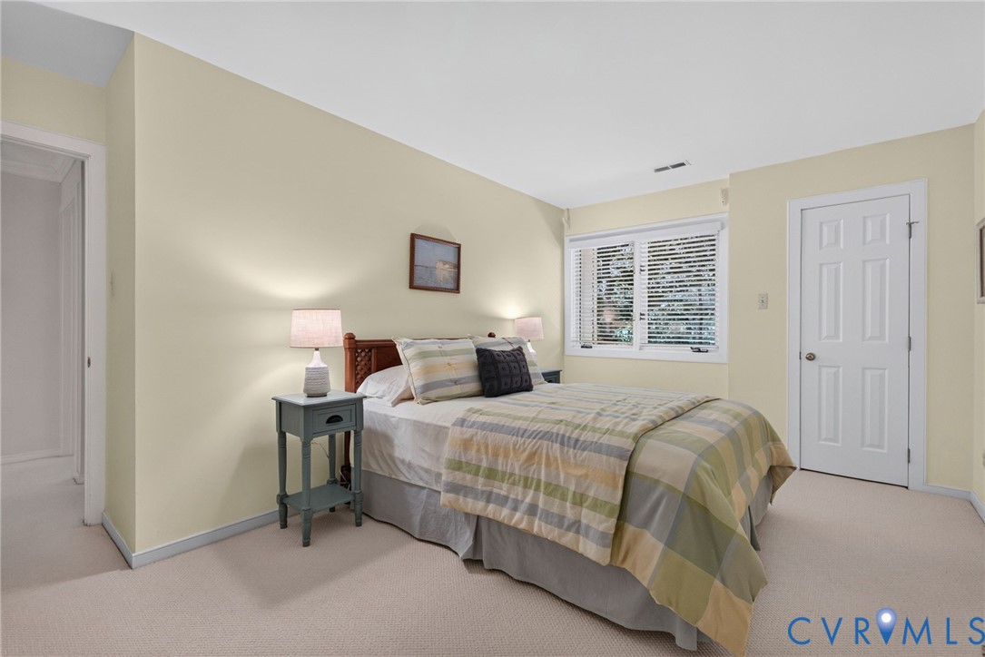 Another spacious bedroom with wooded views and natural light.