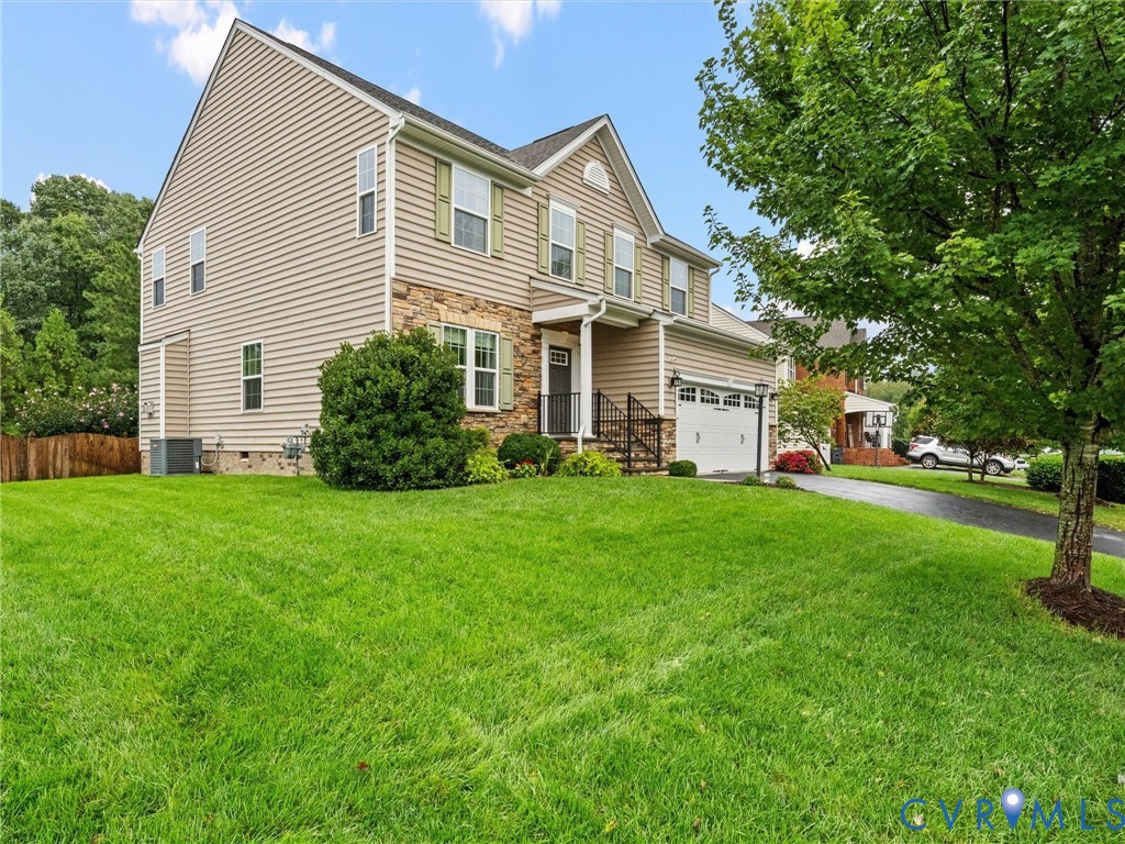 Two-story residence featuring siding and stone accents, an attached garage, and a covered front entry with railing