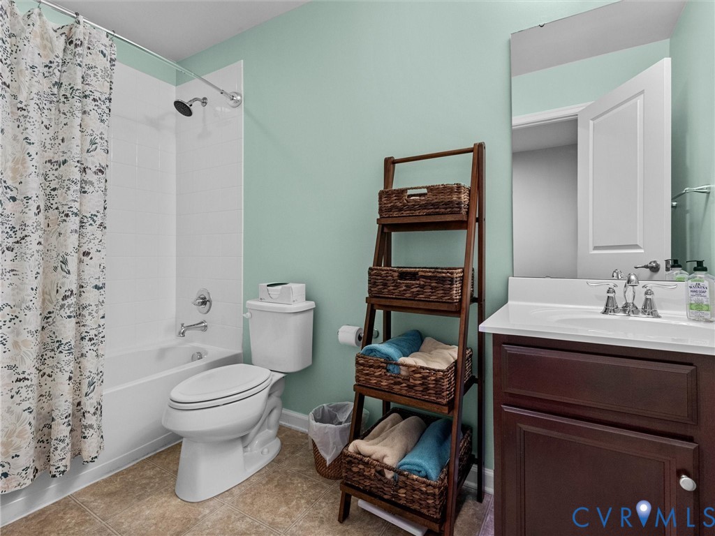 Tub/shower combination with white subway tile surround, white vanity with integrated sink, and chrome fixtures