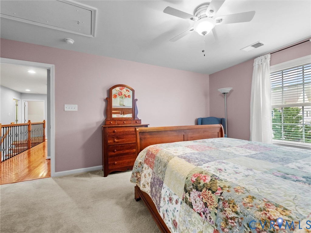 Carpeted bedroom featuring a ceiling fan with integrated lighting, window with blinds, and painted walls