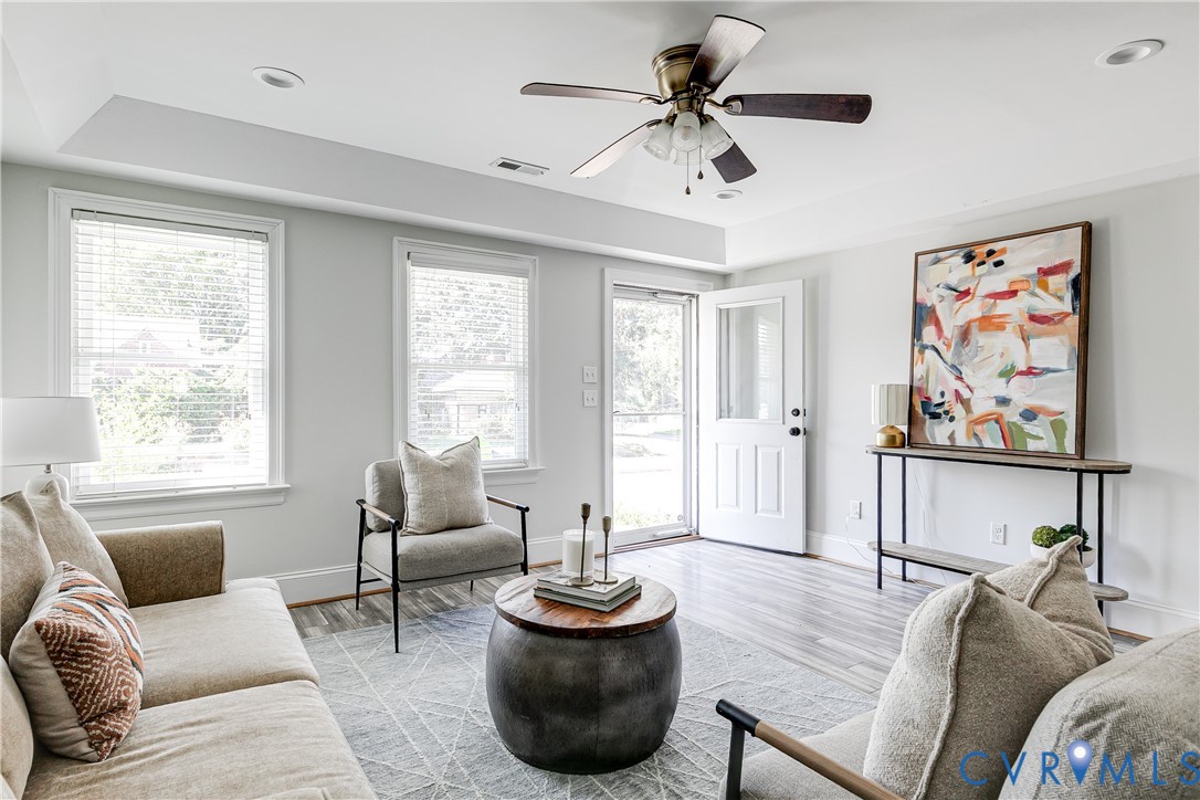 Recessed lighting, ceiling fan, wood-finish flooring, two large windows, and a glass-paneled exterior door
