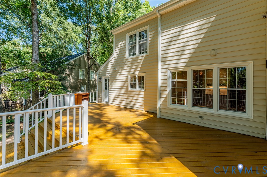 Expansive exterior deck with wood-finish flooring and white railings