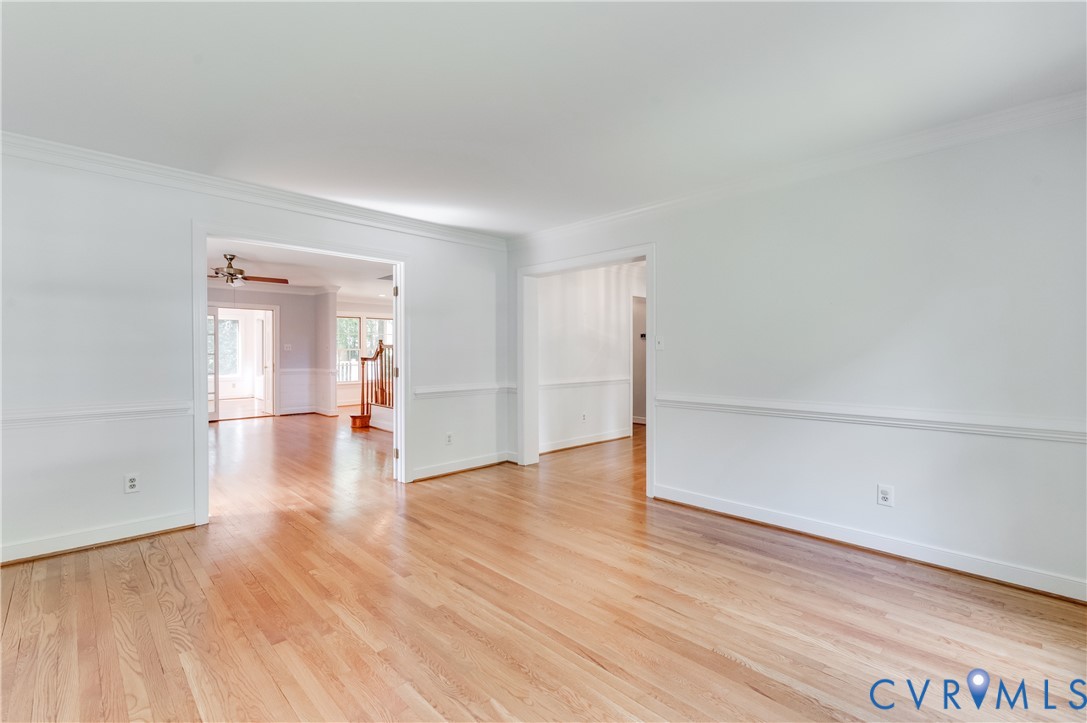 Hardwood flooring, crown molding, chair rail molding, and a ceiling fan